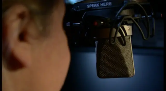 Anonymous person speaking into microphone