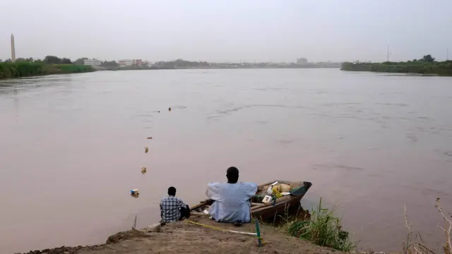 People sit on the banks of the Nile in Khartoum