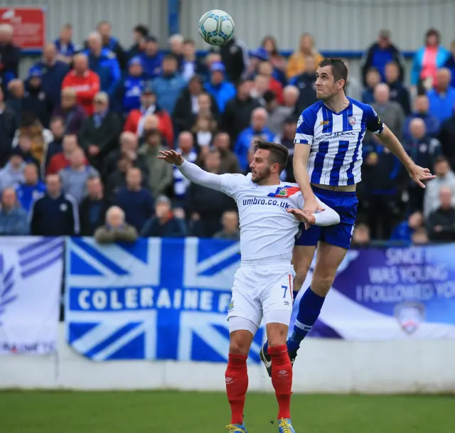 Linfield striker Andrew Waterworth is left standing by this leap from Coleraine defender David Ogilby