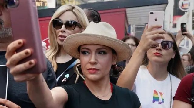 Alyssa Milano holding a phone