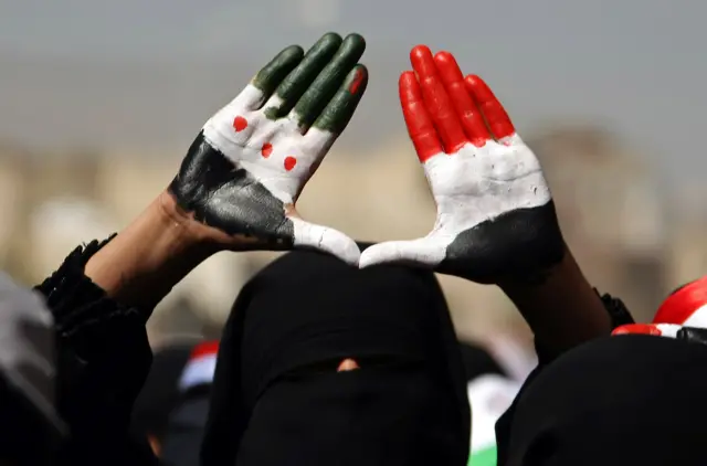 A woman has both Yemeni flags painted on her palms