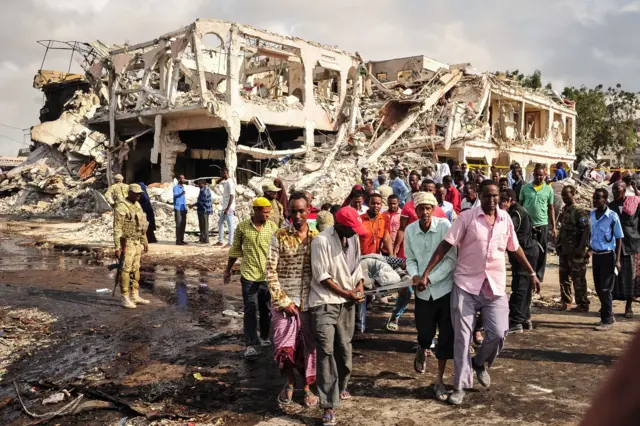 Men carry the body of a victim who died in the explosion