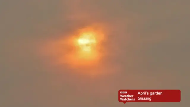 Red sun in cloudy sky