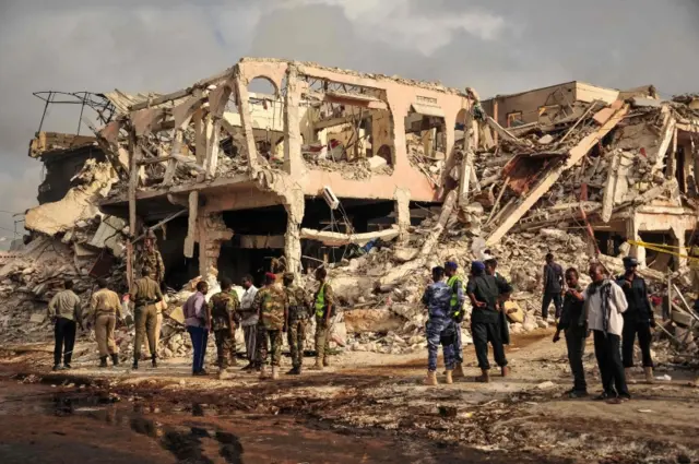 Somali security officers patrol on the scene of the explosion of a truck bomb in the centre of Mogadishu, on October 15, 2017.