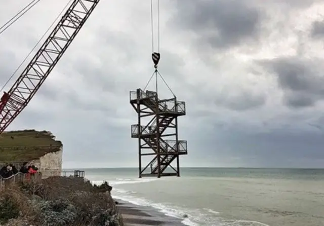 The steps being lifted by a crane