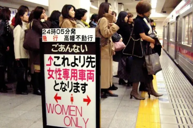 Women on a platform with a sign reading: Women only