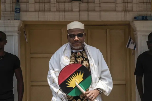 Nnamdi Kanu (L), wearing a Jewish prayer shawl, poses in the garden of his house in Umuahia, southeast Nigeria, on May 26, 2017