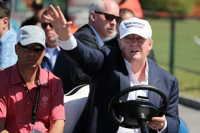 Donald Trump drives a golf buggy