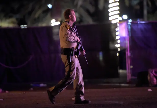 officer with gun walking street looking alert