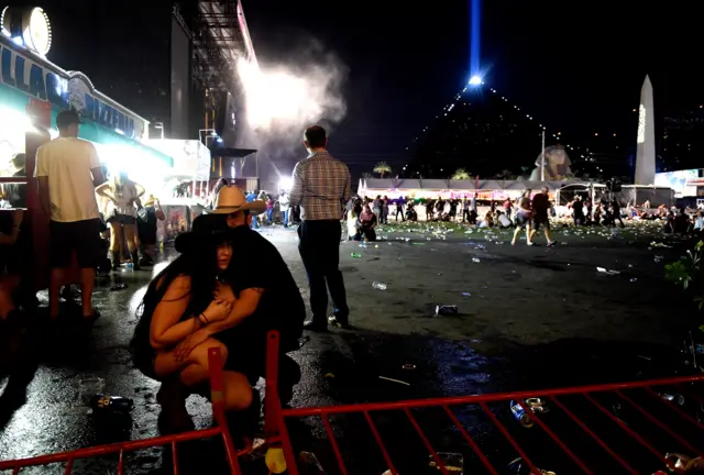 People crouch at the music festival in Las Vegas where the shooting took place