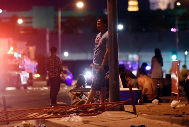 man leaning against post with railings collapsed on street