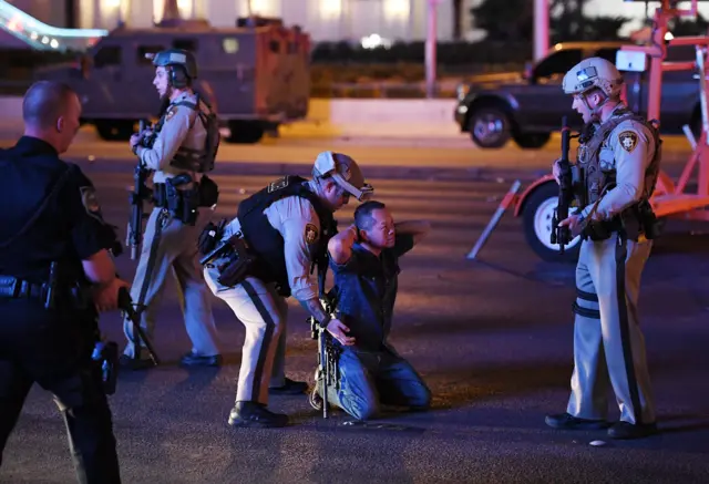 Police officers stop a man who drove down a closed road in Las Vegas