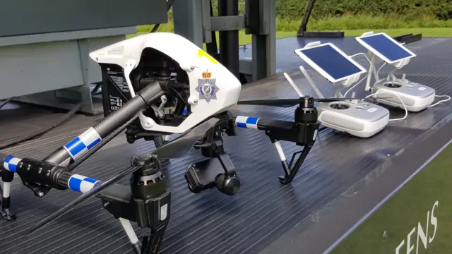 A Police drone sits beside it's controllers