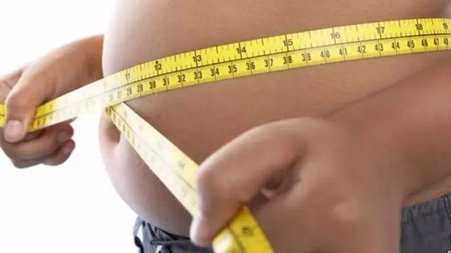 Child with tape measure around waist