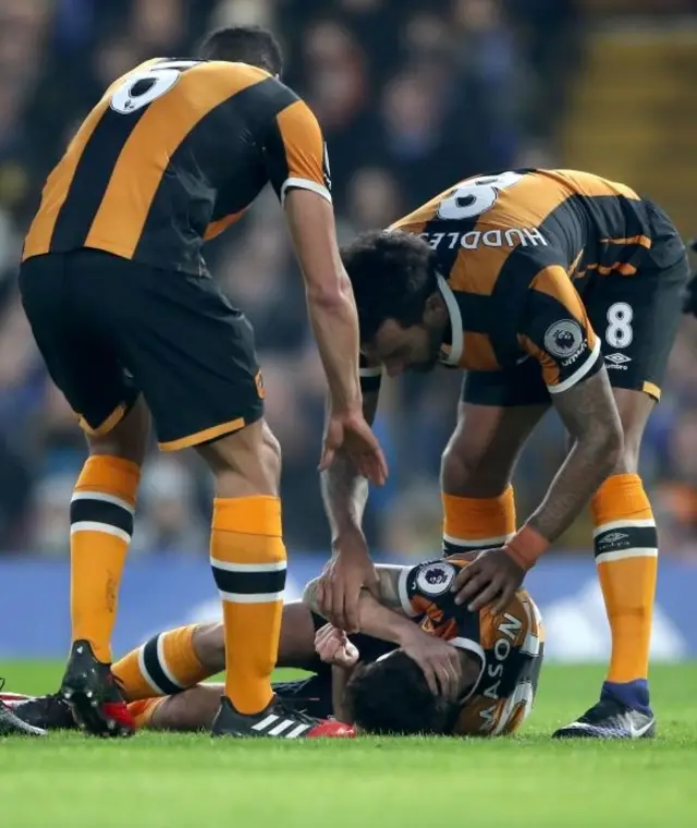 Ryan Mason lies on pitch and holds his head following collision during Premier League match at Stamford Bridge.