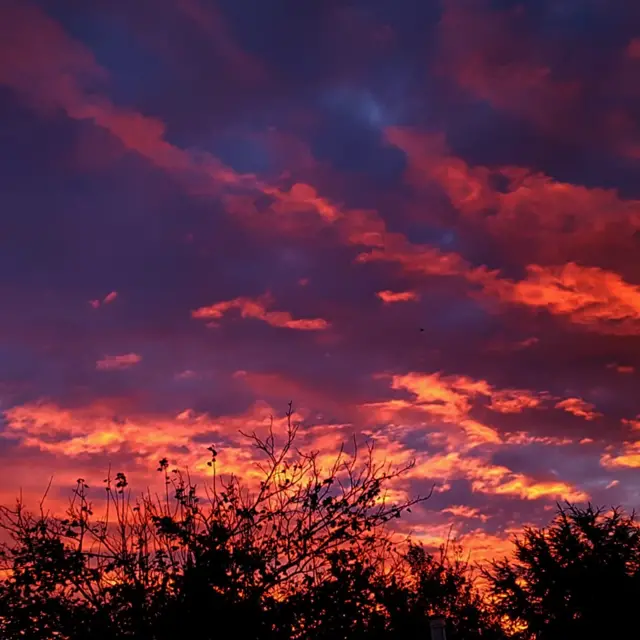 Bright red sunrise reflects in the clouds