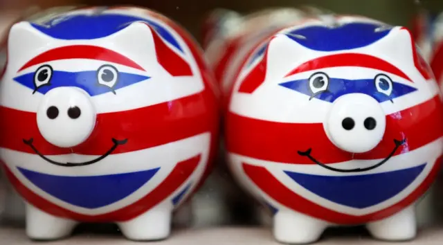 FILE PHOTO: Smiling Union Jack piggy banks are lined up for sale in the window of a souvenir store on Oxford Street in central London January 20, 2014. REUTERS/Andrew Winning/File Photo