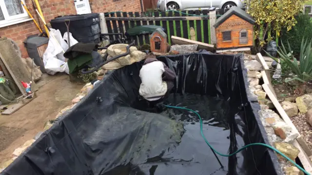 Ricky Booth cleaning pond in memorial garden