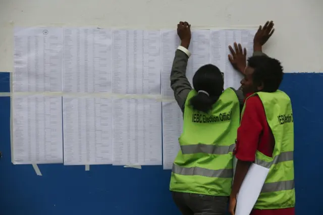 Election clerks from Independent Electoral and Boundaries Commission (IEBC) put up lists containing names of clerks and voters for the polling stations at a school to serve as a polling station in Nairobi, Kenya, 25 October 2017