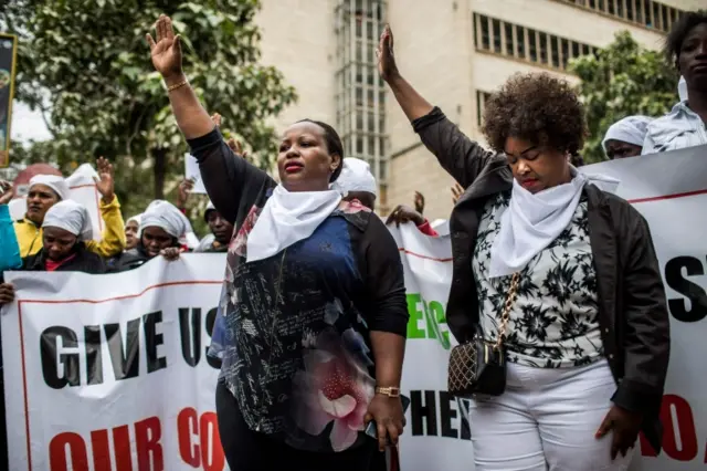 Kenyan women wearing white scarfs pray while staging a multi-faith demonstration calling for peaceful election in downtown Nairobi on October 25, 2017