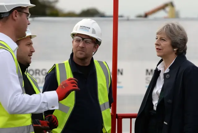 Theresa May at the construction site with representatives from Morgan Sindell