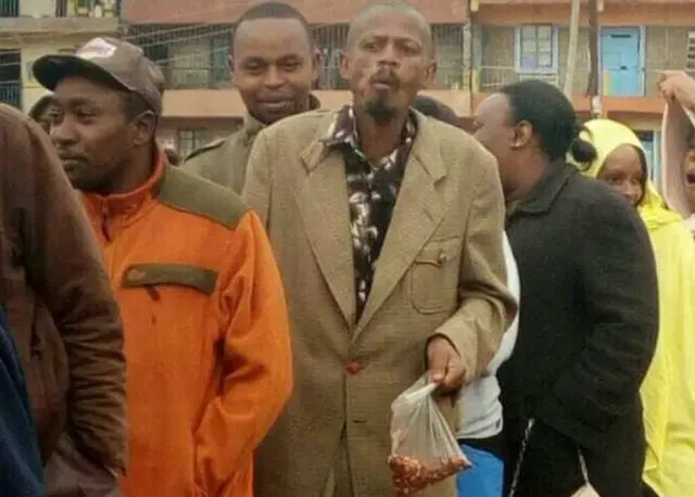 Githeriman seen in a queue holding his bag of snacks