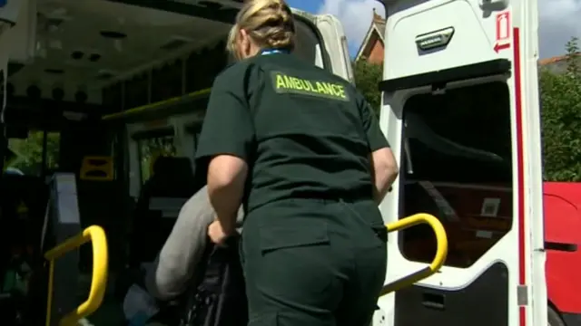 Wheelchair user being wheeled into ambulance