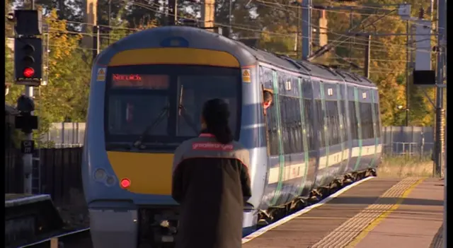 Train with Greater Anglia employee on platform