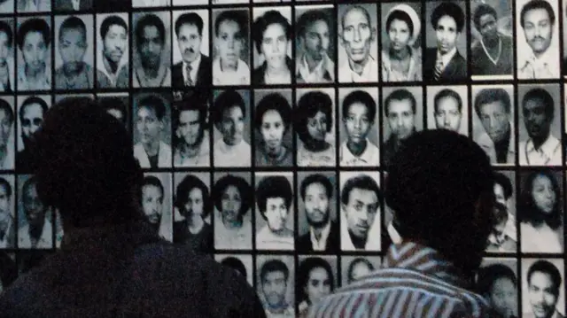 Visitors look at pictures of victims of Ethiopia's Red Terror campaign at a museum in Ethiopia