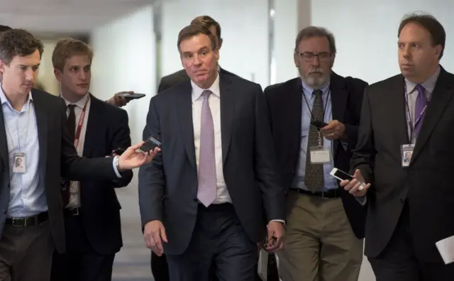 Mark Warner surrounded by reporters