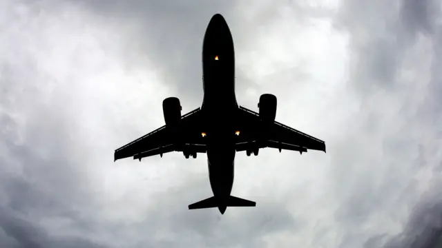 An plane flies over Liverpool's John Lennon airport