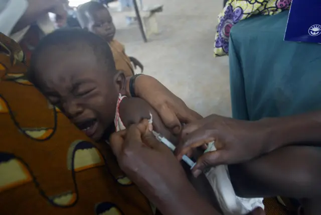 Health worker immunising a child against measles at Alimosho public health centre in Lagos, 03 October, 2006.