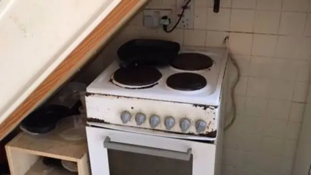 A cooker underneath a staircase in a Jersey rented property