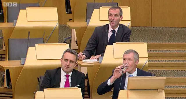 Scottish Lib Dem leader Willie Rennie listens to Derek Mackay's answer to his question.