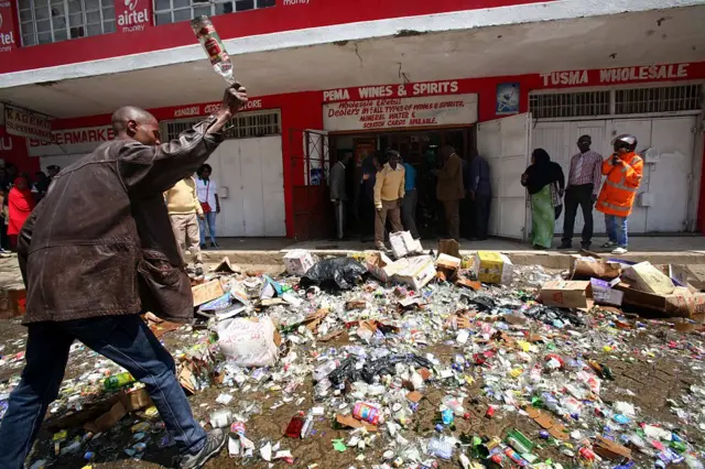 A man smashes bottles containing alcohol