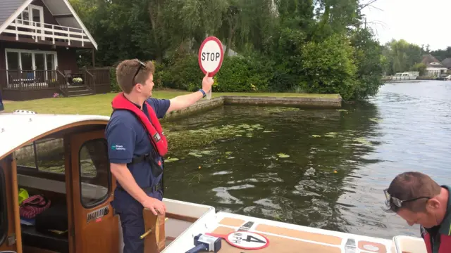 A Ranger holds a "stop" sign