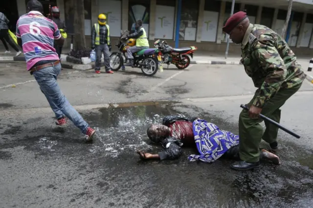 A man dashes to avoid bees after pouring soapy water on a handicapped begger who were unable to escape when a swarm of bees attacked police officers and journalists and got stung severely before being taken away by an ambulance in front of the Supreme Court where judges are delivering the full judgement on the nullified 08 August 2017 presidential election which declared the President Kenyatta the winner, in Nairobi, Kenya, 20 September 2017