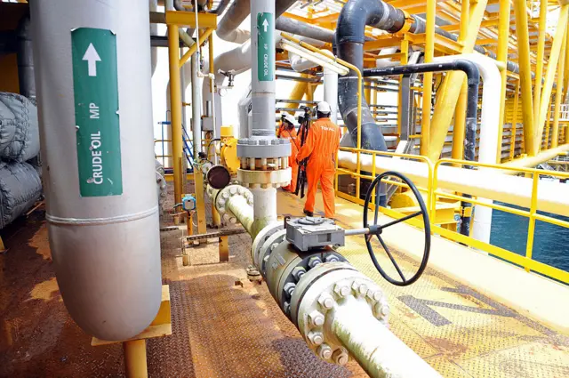 A worker inspect facilities on an upstream oil drilling platform at the Total oil platform at Amenem, 35 kilometers away from Port Harcourt in the Niger Delta