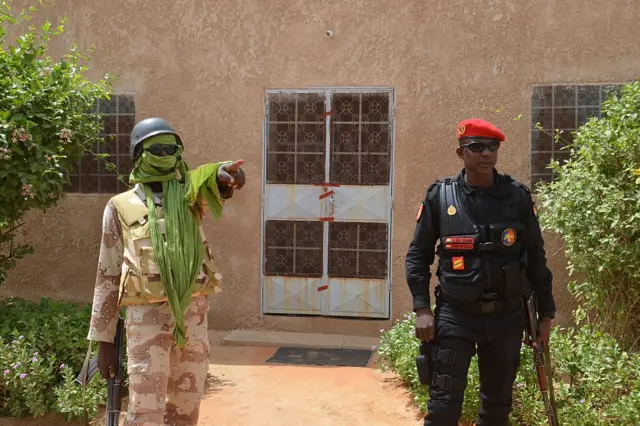 A picture taken on October 19, 2016 shows two members of Niger's security forces standing guard outside the home of a US aid worker who was kidnapped on October 14 by armed men in Abalak in the region of Tahoua