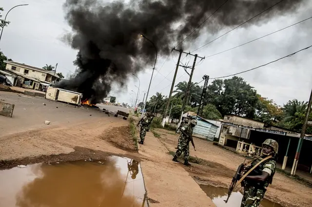 Burundian peacekeepers of the African-led International Support Mission to the Central African Republic (MISCA) patrol near a barricade of burning tyres erected in the Bea-Rex district of Bangui on May 29, 2014