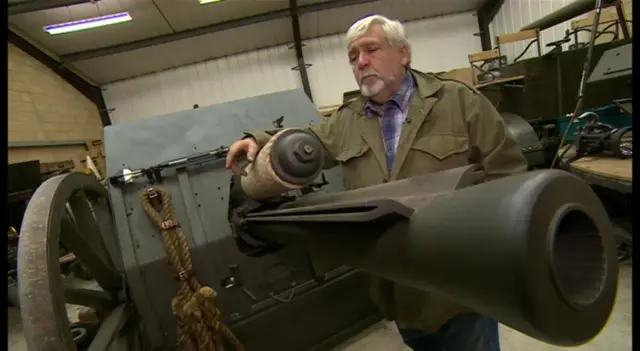 Man standing beside WW1 gun