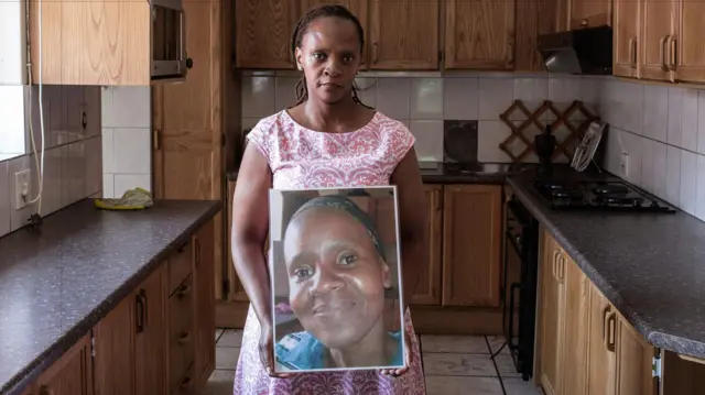 Christine Nxumalo poses with a picture of her sister of Virginia Nxumalo, a mentally ill patient who died in Gauteng province last year