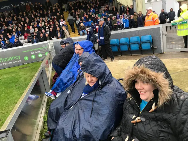 Wheelchair users in rain at stadium