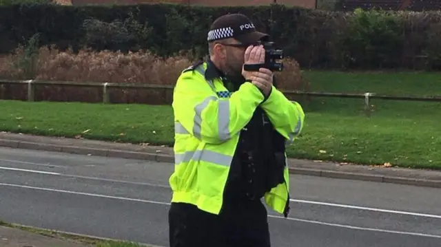 Policeman with a speed camera