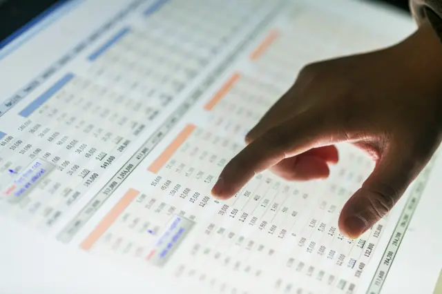 A man pointing at data on a screen