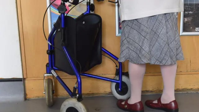 Elderly patient with mobility assistance walker.