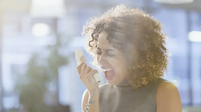 Stressed woman shouting into phone