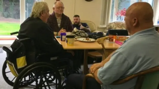 Three veterans sat around a table talking.