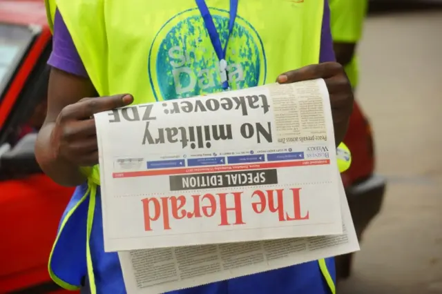 A man reads the front page of a special edition of The Herald newspaper about the crisis in Zimbabwe on November 15, 2017 in Harare