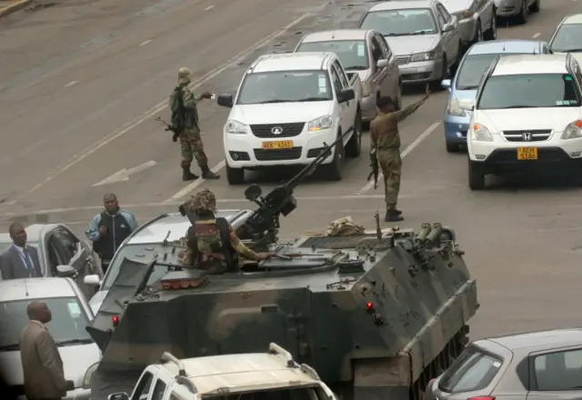 Drivers get out of their cars to look at the soldiers in the streets